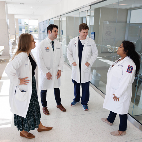 Group photo of four residents talking in hallway